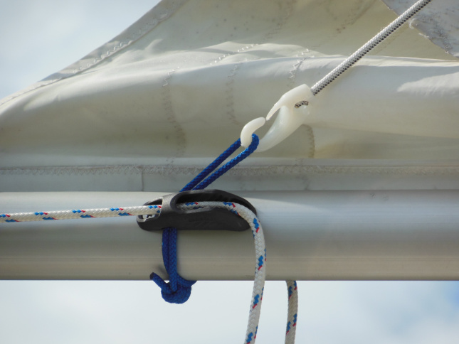 Standing end of shock cord attached to a loop through the topping lift cleat