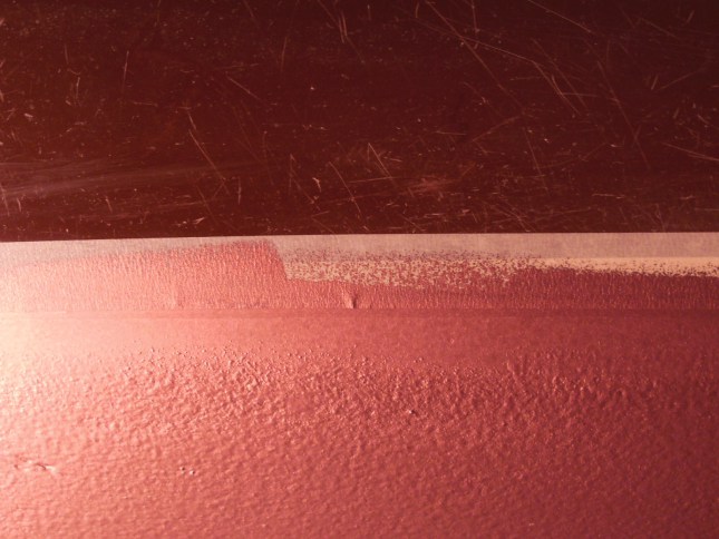 Closeup of bottom paint below the boot stripe before removing the masking tape